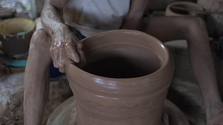 the traditional potter craftsman working using hands and legs, throwing technique