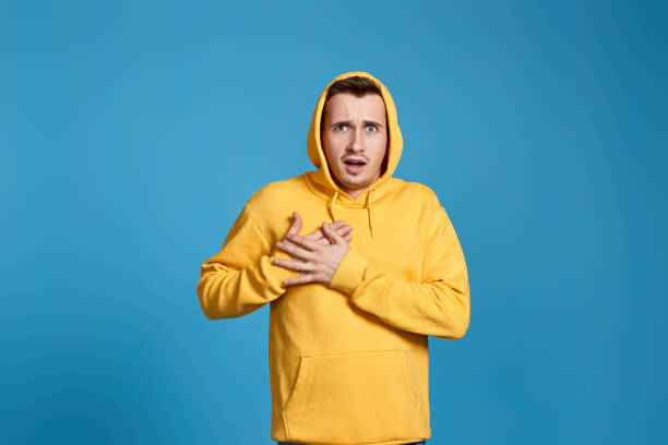 istock young man in yellow sweatshirt with hands on chest 1452987838