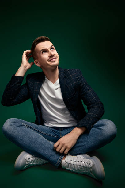 istock handsome man in plaid jacket sitting on the floor 1452987848