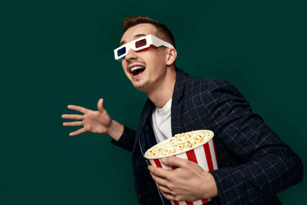 istock guy in 3d glasses eating popcorn on pink background 1452987868