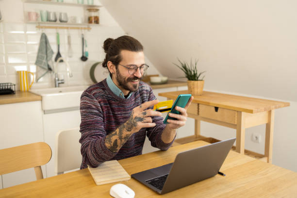 istock Happy man enjoying at home and shopping online 1452992143