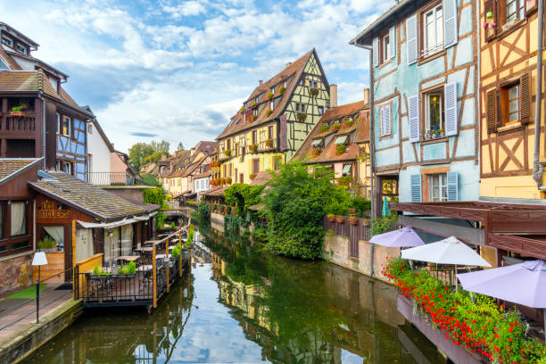 picturesque half timber buildings with waterfront cafes along the canal and lauch river in the medieval historic center of colmar, france, in the alsace region. - haut rhin imagens e fotografias de stock