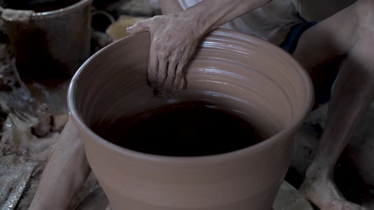 throwing technique of making pottery, the traditional potter craftsman working using hands and legs