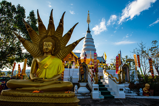 White pagoda with Buddha statue in Phrathat Doi Leng temple, Thailand.