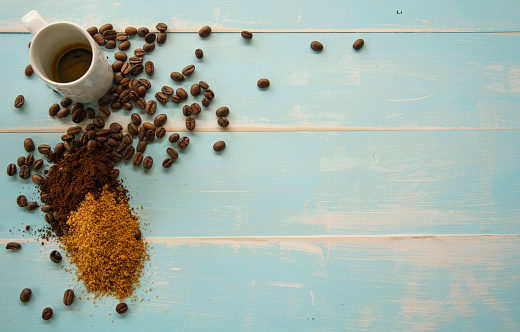Coffee, beans, ground on pale blue timber background