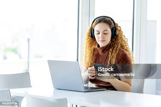 Redhaired Woman Takes A Break At The Office Stock Photo - Download Image Now - Music Streaming Service, Concentration, Music