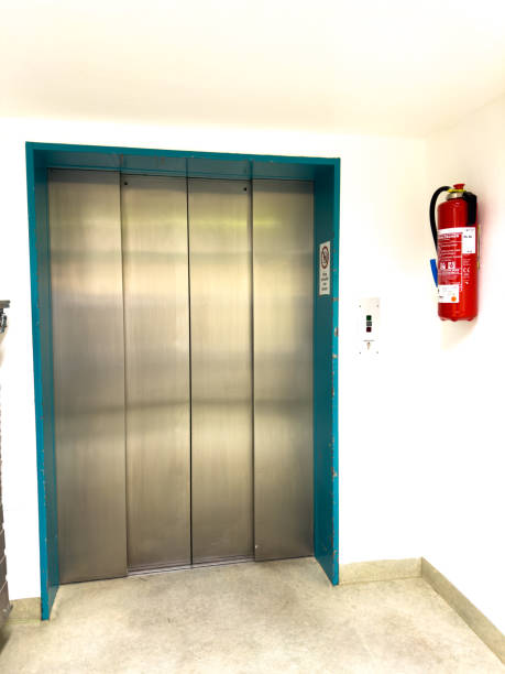 istock next to an elevator hangs a large red hand fire extinguisher 1453022240