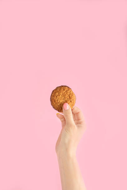 istock Arms raised up holding coffee cup on pink background. 1453024998