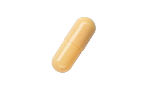 istock yellow pill capsule isolated on white background 1453027747