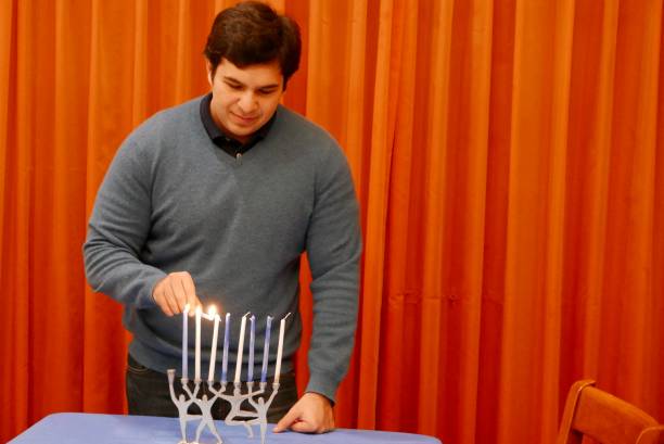 College male lighting candles on a menorah for Hanukah