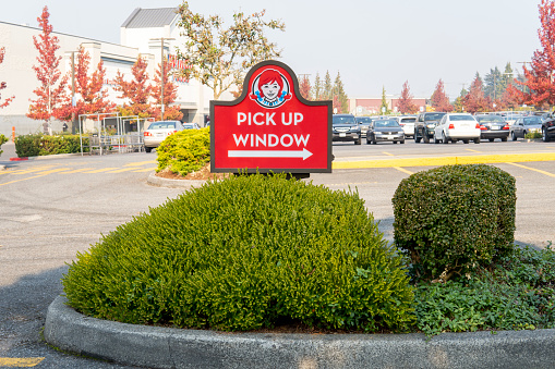 Sign of Wendy's restaurant with arrow and inscription - Pick up window. Wendy's is American international fast food restaurant chain. Everett, WA, USA - October 2022