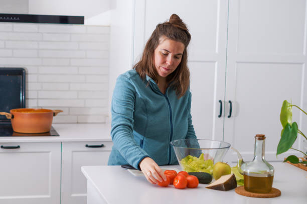 istock young girl preparing a salad in the kitchen 1453040753