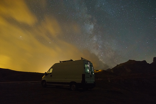 Milky Way in the night sky over camper van in the Pyrenees mountains, Col du Pourtalet, Nouvelle-Aquitaine, France