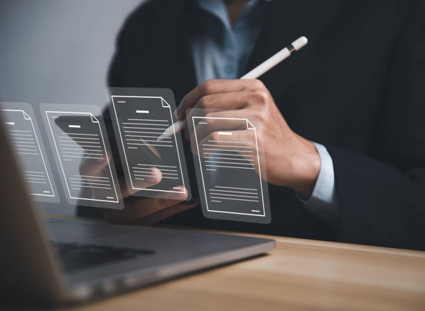 istock Businessman using laptop and smartphone to manage electronic documents Access to online business document databases paperless office 1453043403