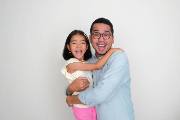 A father and daughter hugging together with happy face expression A father and daughter hugging together with happy face expression keluarga stock pictures, royalty-free photos & images