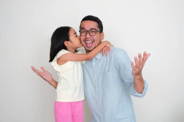 A father showing happy expression when his daughter kiss his cheek A father showing happy expression when his daughter kiss his cheek keluarga stock pictures, royalty-free photos & images