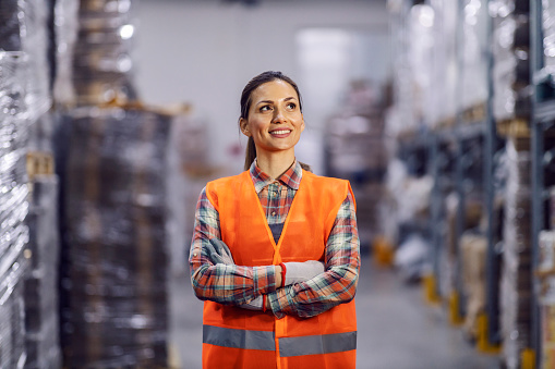 A smiling storage worker is standing confidently in facility.