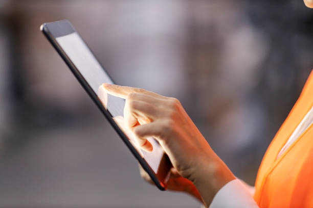 istock Close up of a warehouse worker scrolling on tablet. 1453045166