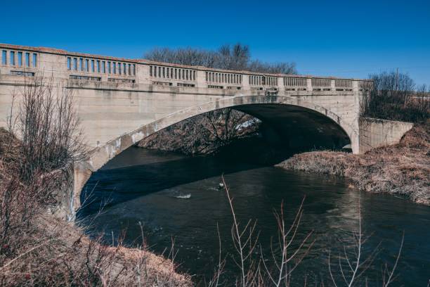 istock River flowing under an arched bridge against a blue sky 1453046079