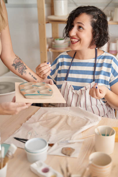 istock Woman with apron enjoying while having a pottery class. 1453047878