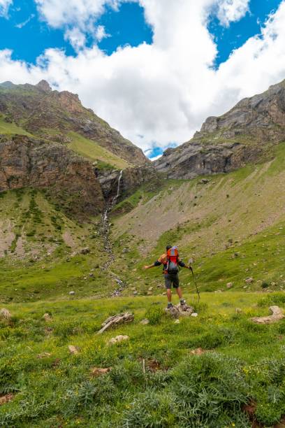 istock Young man visiting the waterfall in the valley 1453049832