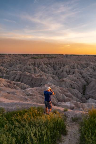 istock Tourist Watching the Sunset over Badlands 1453050282