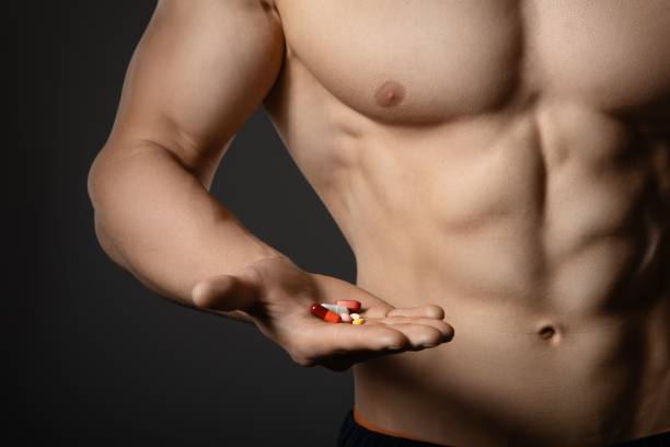 Man holding anabolic steroids or booster supplements in hand Athletic man holding anabolic steroids or booster supplements in hand anti doping stock pictures, royalty-free photos & images