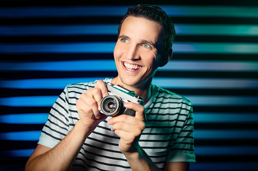 A happy and joyful photographer with an old camera in his hands