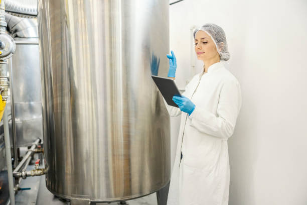 istock An expert standing with tablet next to a milk processing machine in dairy. 1453051811
