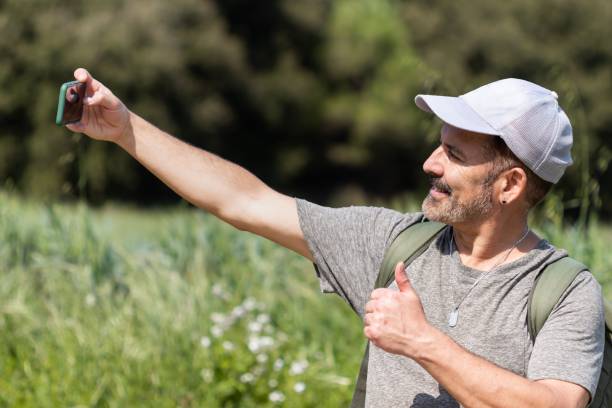 istock Happy man on vacation in a grain field taking a selfie. 1453053694