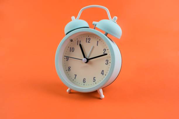 istock Alarm clock isolated on an orange background 1453057025