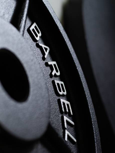 istock Vertical closeup shot of a barbell weight on a blurry background 1453058005