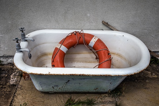 An abandoned old bath containing a lifebuoy.
