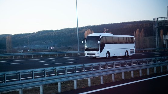 White passenger bus going on highway