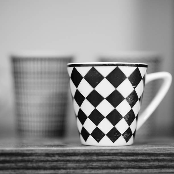 Grayscale shot of a cup in a shelf