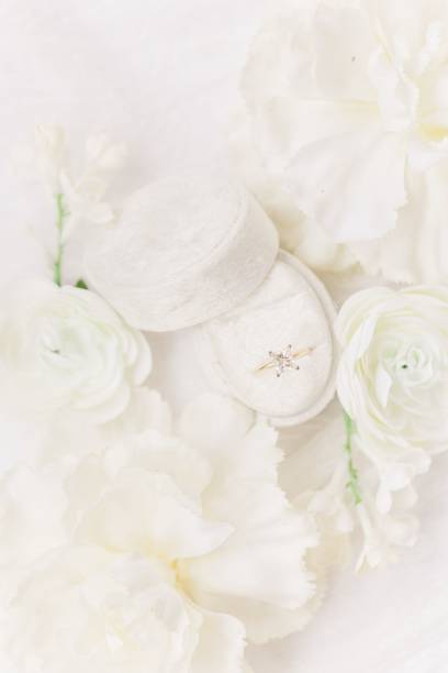 istock Vertical top view of a wedding ring in a box surrounded by flowers 1453062039