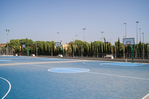 A basketball court in a public park on a sunny morning