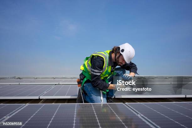 Blue Collar Worker Install Solar Panel On Rooftop Stock Photo - Download Image Now - 20-24 Years, Adult, Adults Only