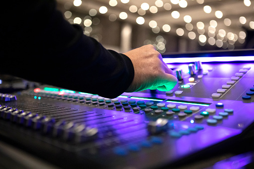 Sound recording studio mixer desk: professional music production.
Hand of a man on Mixing Console e of a big HiFi system with many leds potentiometers.