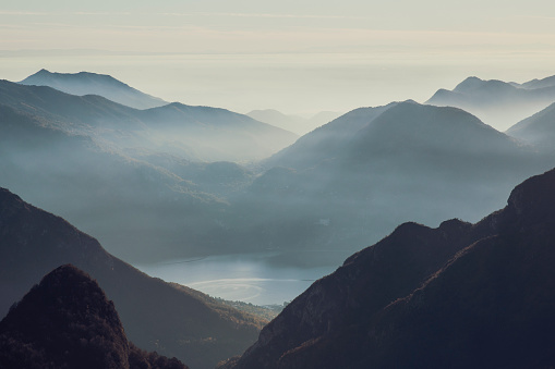 Aerial view of misty mountains with lake at twilight