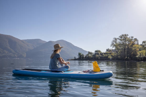Woman relaxes on stand up paddle stock photo