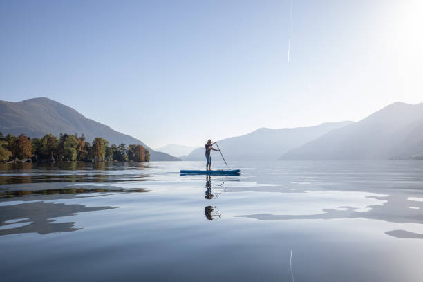 Woman stand up paddling on a lake stock photo