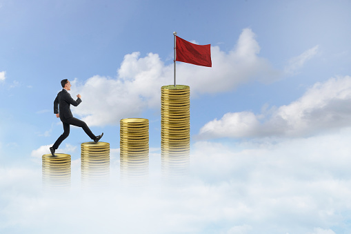 Asian businessman climb coin stairs with blue sky background