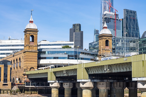 Cannon Street Railway Bridge. In the background is the skyline of the City of London including global architectural buildings.