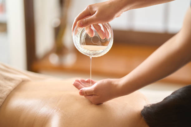 esteticista goteando aceite de masaje en el salón de belleza - massaging human arm obscured face only women fotografías e imágenes de stock