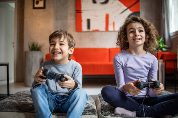 istock Two little kids, brother and sister play video game console using joystick 1453096314