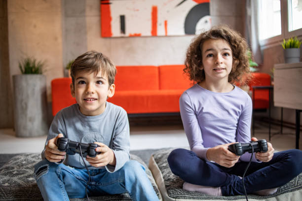 istock Two little kids, brother and sister play video game console using joystick 1453096328