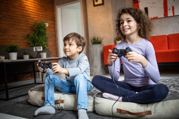 istock Two little kids, brother and sister play video game console using joystick 1453096330