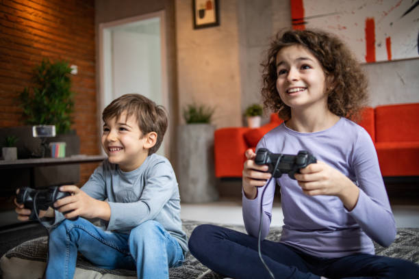 istock Two little kids, brother and sister play video game console using joystick 1453096344
