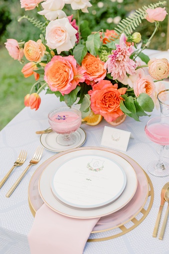A vertical shot of an outdoor wedding table with flowers and elegant tableware